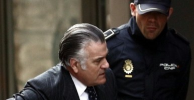 Luis Bárcenas, el extesorero del PP, accediendo a los juzgados custodiado por un agente de Policía / EFE