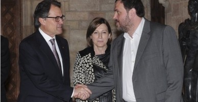 Artur Mas y el lider de (ERC), Oriol Junqueras, se estrechan la mano ante la mirada de la presidenta de (ANC), Carme Forcadell / foto AFP