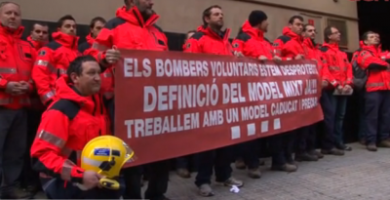 Agentes del Cuerpo de Bomberos Voluntarios de Cataluña posando ante la oficina de la delegación del Gobierno regional donde presentaron su dimisión