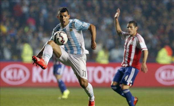 El delantero argentino Sergio Agüero (i) controla el balón ante