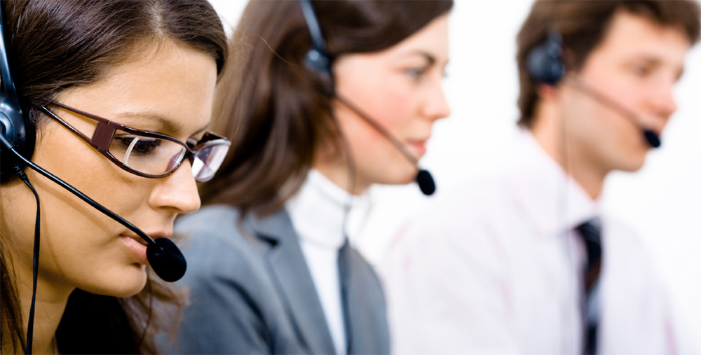 Dos mujeres y un hombre atendiendo a los clientes por teléfono en una empresa. Foto-Facua