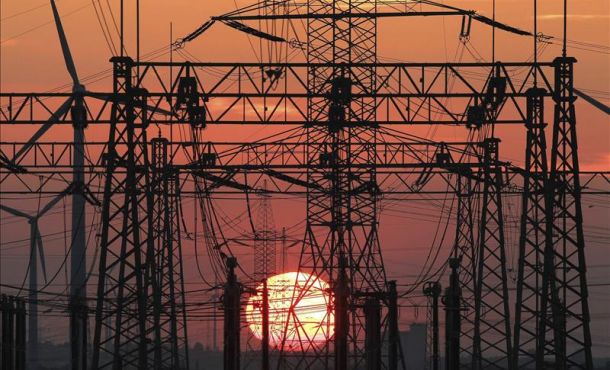 En la imagen, una puesta de sol junto al tendido eléctrico y unos molinos de viento. EFE