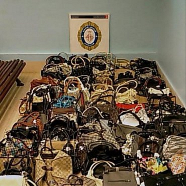 Fotografía facilitada por la Guardia Urbana que ha intervenido más de 140 bolsos de piel y de tela y 156 chapas falsas de conocidas marcas de lujo, EFE