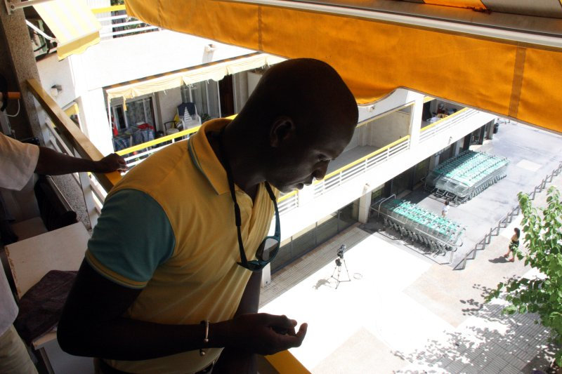 Ibrahima Sylla, germà de l'home mort a Salou, mirant cap al carrer des del balcó on es van produir els fets. Foto ACN