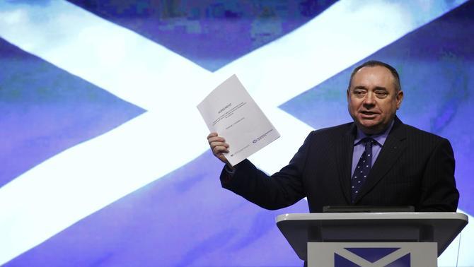 Scotland First Minister Alex Salmond holds a copy of the agreement on a referendum of independence for Scotland during a news conference in Edinburgh