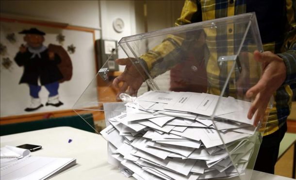 El presidente de una mesa electoral deposita los votos de la urna sobre una mesa para proceder a su recuento. EFE