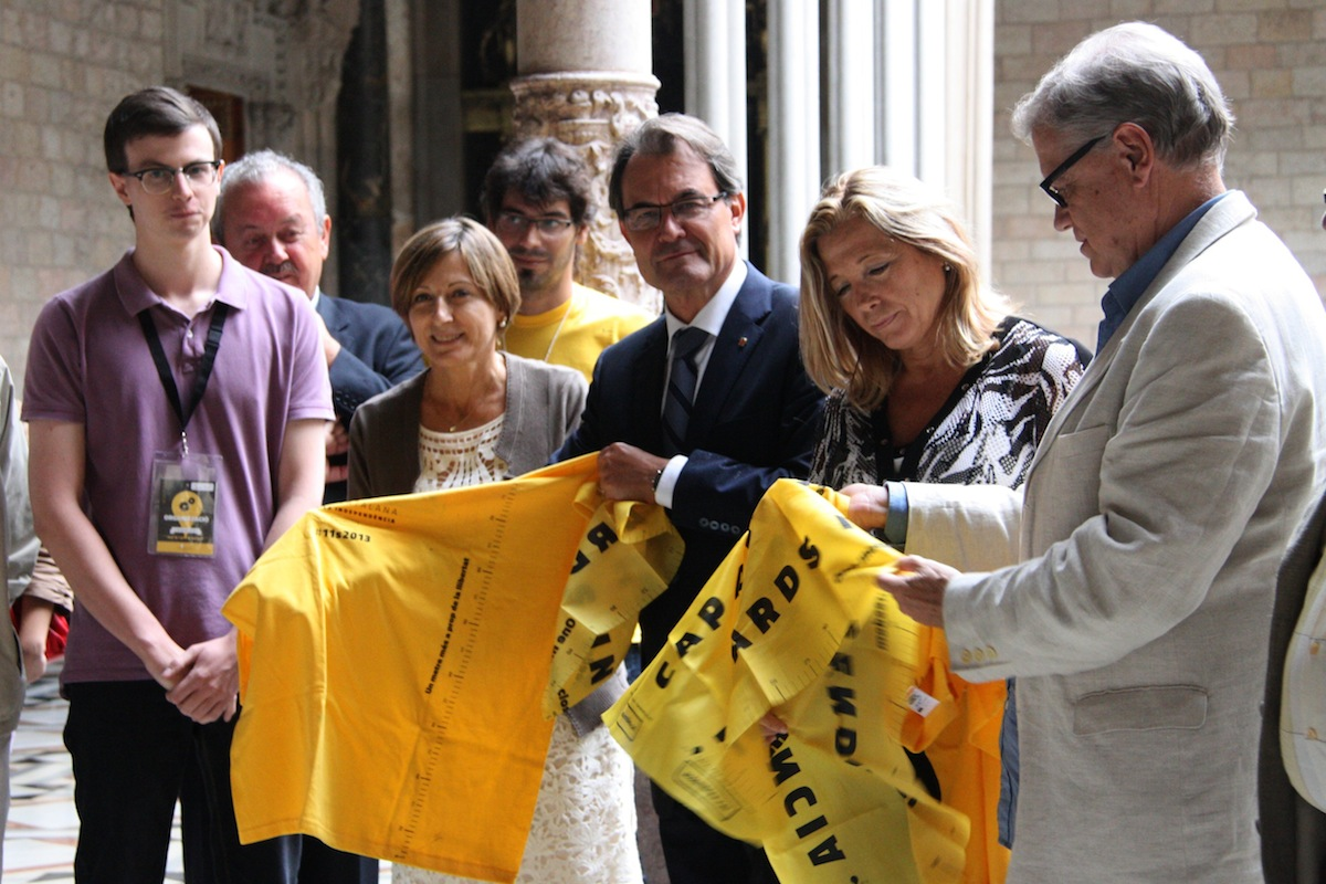 la expresidenta de ANC, Forcadell (i) entregando una camiseta de vía separatista catalana a Mas (c) y la vicepresidenta, Ortega (d), en palacio de gobierno catalán. Lasvocesdelpueblo