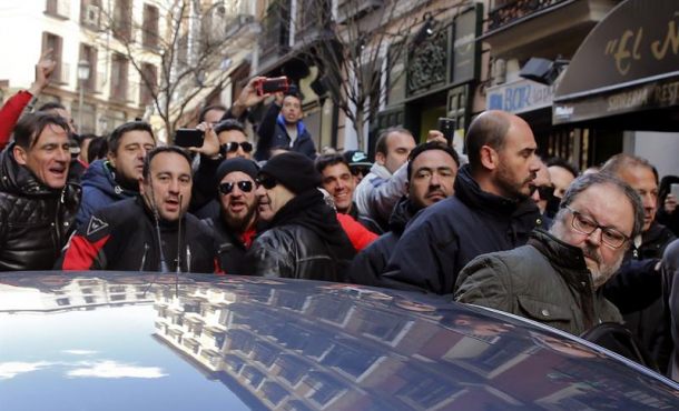 El concejal de Salud, Seguridad y Emergencias de Madrid, Javier Barbero (d) se introduce en un coche mientras es increpado por los asistentes a una concentración de policías municipales, EFE