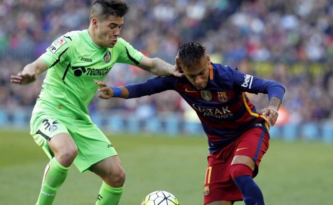 El delantero brasileño del FC Barcelona Neymar da Silva (d) pelea un balón con el defensa del Getafe Emiliano Buendía durante el partido correspondiente a la 29 jornada de la liga. Efe