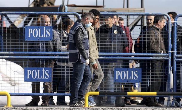 Refugiados son escoltados abordo de un ferri en el puerto de Mytilene en la isla de Lesbos en Grecia, este lunes. EFE