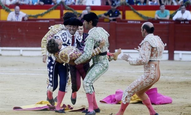 El diestro sevillano Manuel Escribano, es trasladado por su cuadrilla tras ser corneado por el segundo de su lote, durante la cuarta de la feria de San Juan... Efe