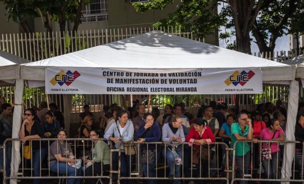 Un grupo de personas espera en un salón para validar firmas y datos personales ante el Consejo Nacional Electoral de Venezuela... EFE