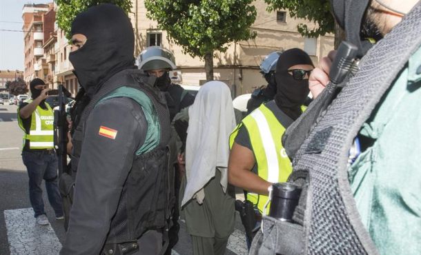 Miembros de la Guardia Civil custodian a uno de los tres hermanos pakistaníes detenidos hoy, en el barrio de Pardinyes de Lleida, por enaltecimie... EFE