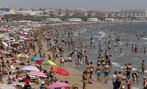 Miles de personas abarrotaban esta mañana la playa de la Malvarrosa de Valencia en el primer fin de semana de julio. EFE