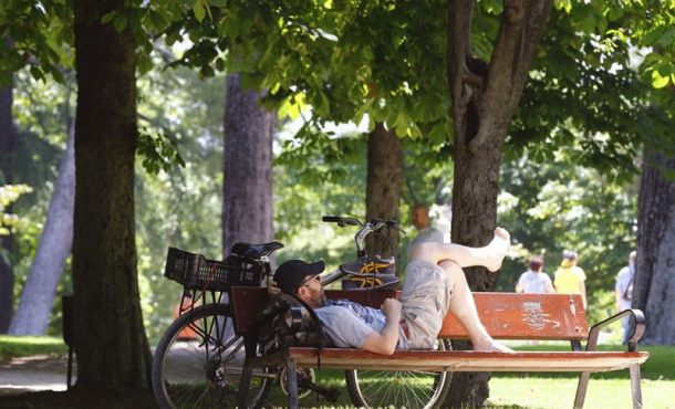 Un hombre descansa en un banco a la sombra en el madrileño parque del Retiro. Archivo Efe.