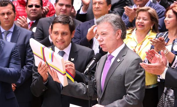 El presidente de Colombia, Juan Manuel Santos (d), entrega al presidente del Congreso de Colombia, Mauricio Lizcano (c), el texto definitivo del acuerdo de paz con la guerrilla... Efe