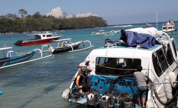 En la imagen de ayer, expertos examinan el ferry siniestrado en el puerto de Padangbai. EFE