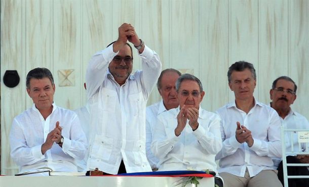 El máximo líder de las Fuerzas Armadas Revolucionarias de Colombia (FARC), Rodrigo Londoño Echeverri (frente), alias alias "Timochenko", saluda tras firmar el acuerdo de paz frente al presidente de Colombia, Juan Manuel Santos (i), y los presidentes de Cuba, Raúl Castro (3-d), y de Argentina, Mauricio Macri (2-d), en la ceremonia de la firma del acuerdo de paz en la ciudad de Cartagena. EFE 