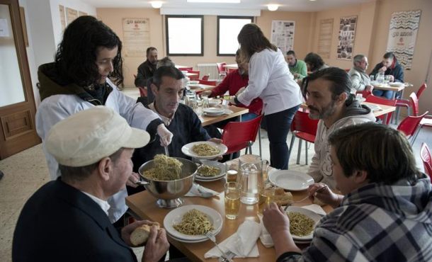 una-voluntaria-sirve-comida-a-un-grupo-de-personas-sin-recursos-en-un-comedor-social-de-caritas-archivo-efe