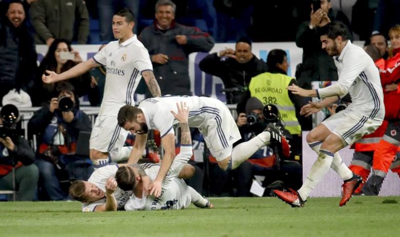 El defensa del Real Madrid Sergio Ramos (en el suelo) celebra su gol, el tercero de su equipo frente al Deportivo de La Coruña, durante el partido de la decimoquinta jornada de Liga en Primera División que se jugó en el estadio Santiago Bernabéu, en Madrid. Efe