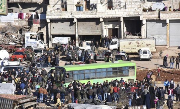 Fotografía facilitada por la Agencia Árabe Siria de Noticias (SANA), que muestra a los civiles, combatientes y sus familiares accediendo a uno de los autobuses durante los trabajos de evacuación de los barrios rebeldes de Alepo, Siria, el jueves. Efe.
