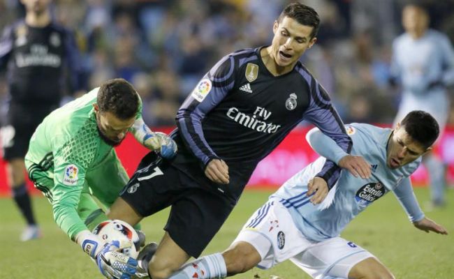 El delantero portugués del Real Madrid, Cristiano Ronaldo (c), cae ante los jugadores del Celta de Vigo, el guardameta Sergio Álvarez (i) y el defensa argentino Facundo Roncaglia, durante el encuentro correspondiente a la vuelta de los cuartos de final de la Copa del Rey, que disputaron en el estadio vigués de Balaidos. Efe