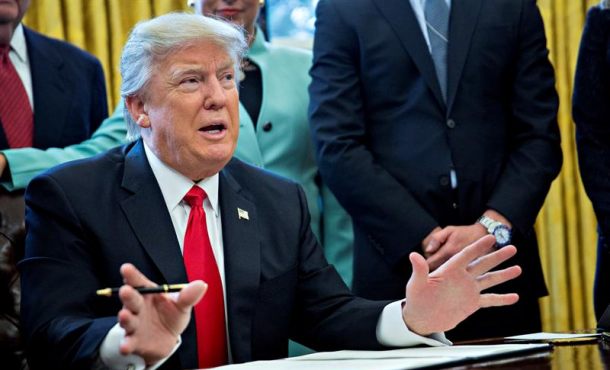 El presidente de EEUU, Donald Trump (c) firma una orden ejecutiva para reducir las trabas administrativas para las pequeñas empresas en el despacho Oval... Efe
