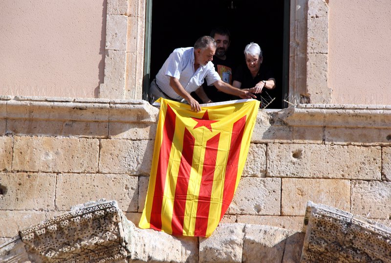 L'alcalde de Torredembarra, Enric Grangel (PSC), penjant l'estelada a la façana de l'Ajuntament, acompanyat dels regidors Rosa Maria Guasch (CiU) i Lluís Suñé (ABG). (Horitzontal)