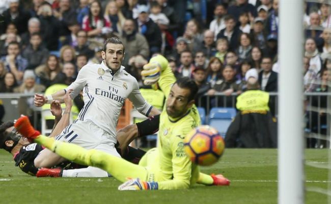 El delantero galés del Real Madrid Gareth Bale marca un gol en la portería de Diego López del RCD Español durante el partido correspondiente a la 23 jornada de Liga, que ambos equipos jugaron en el estadio Santiago Bernabéu, en Madrid. Efe.