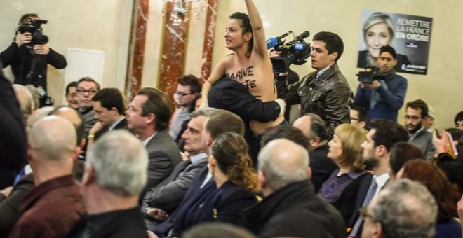 Una extremista feminista del grupo ultrafeminista denominado 'Femen' interrumpe la rueda de prensa de la líder del partido de la derecha en Francia. Efe