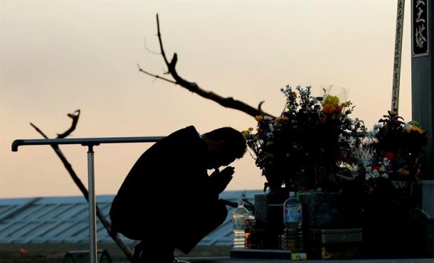 Un hombre reza ante un altar en memoria de las víctimas del terremoto y posterior tsunami, registrado el 11 de marzo de 2004 en Japón. Archivo Efe.