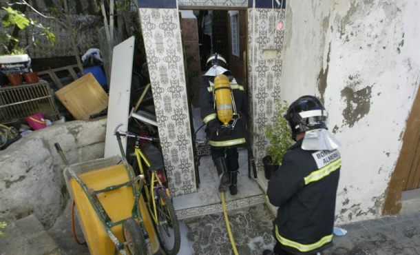 Dos bomberos trabajan en la extinción de un incendio en una casa cueva. Archivo Efe.