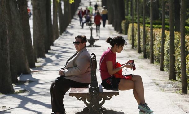 Dos mujeres descansaban sentadas al sol hace unos días en el Parque del Retiro de Madrid. Efe.