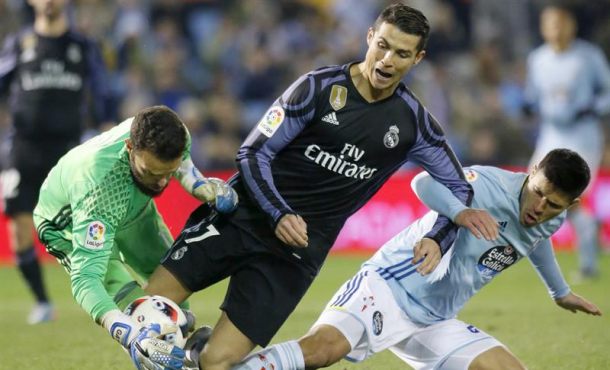 El delantero portugués del Real Madrid, Cristiano Ronaldo (c), cae ante los jugadores del Celta de Vigo, el guardameta Sergio Álvarez (i). Archivo Efe.