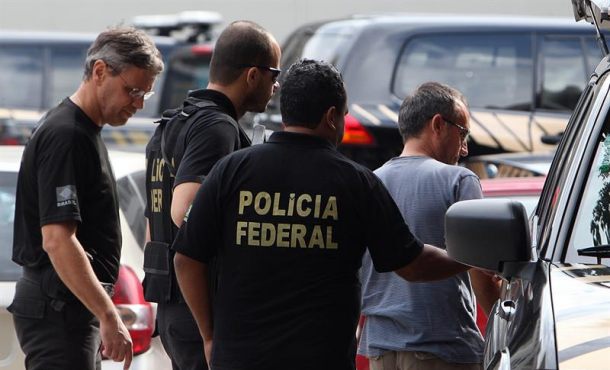 El presunto miembro de la banda terrorista ETA Joseba Gotzon Vizan González (d) es escoltado por miembros de la Policía Federal en Río de Janeiro (Brasil). Efe.
