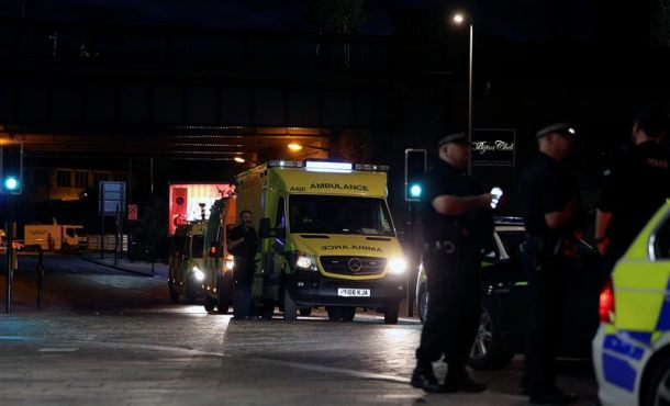 Miembros de la policía fueron registrados al asegurar el área del estadio Manchester Arena, mientras vehículos de emergencia evacúan la zona tras una explosió. Efe.