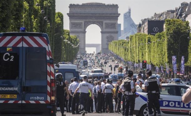 Agentes de policía galos permanecen en guardia en la céntrica avenida de los Campos Elíseos de París, donde un coche impactó el lunes contra un furgón de la Gendarmería francesa. Efe