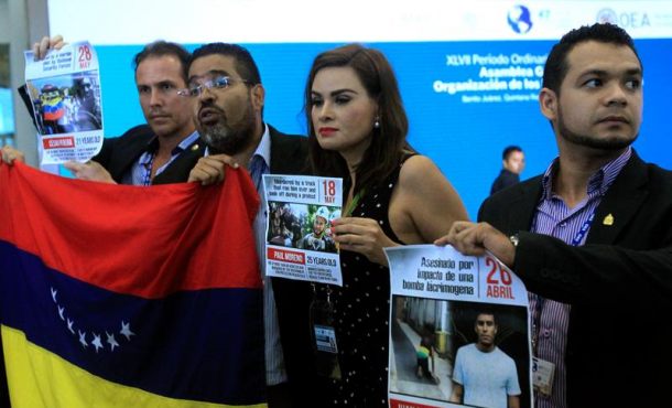 Opositores venezolanos sostienen carteles durante una protesta a la salida de la tercera plenaria de Ministros de Relaciones Exteriores de la 47 Asamblea. Efe