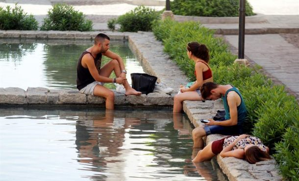 Unos jóvenes ayer en una de las fuentes del centro de Córdoba. Efe.