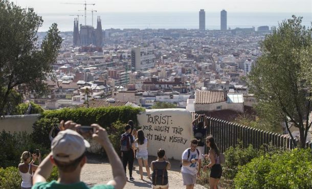 Un grupo de turistas pasea por los alrededores del Parque Guell de Barcelona , donde últimamente han aparecido pintadas contrarias al turismo masificado, Efe