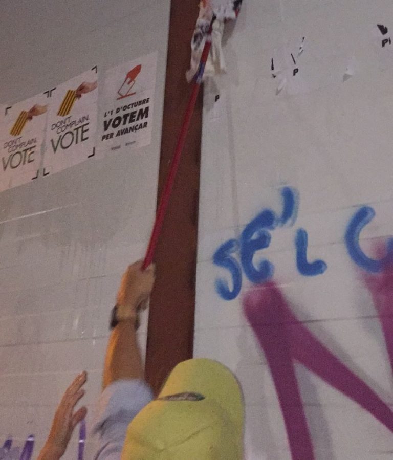 Jóvenes catalanes arrancan carteles ilegales del 1-O en las calles de Cataluña
