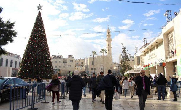 BELÉN (CISJORDANIA), 24.12.2017. La Plaza del Pesebre de Belén, con el árbol, la mezquita de fondo y la gente que asistió a los desfiles. Las festividades de Navidad comenzaron hoy. efe