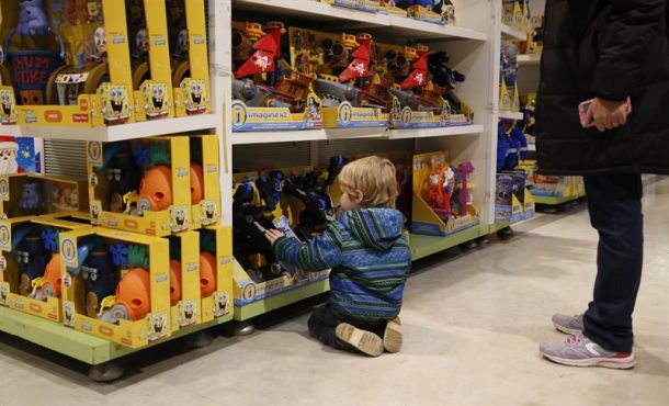 Un niño selecciona un juguete ante su padre. Archivo Efe