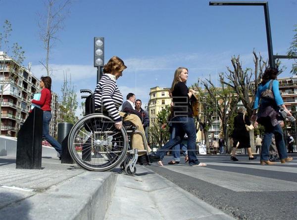 MADRID (ESPAÑA), 03.12.2016. Una mujer pasea en silla de ruedas por una calle de Granada.. Efe