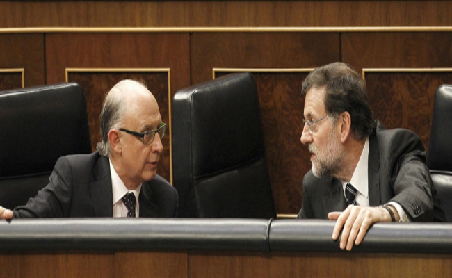 El presidente de Gobierno y del PP, Mariano Rajoy (d), conversa con el ministro de Hacienda, Cristóbal Montoro, en el Congreso de los Diputados, en una imagen de archivo Efe.