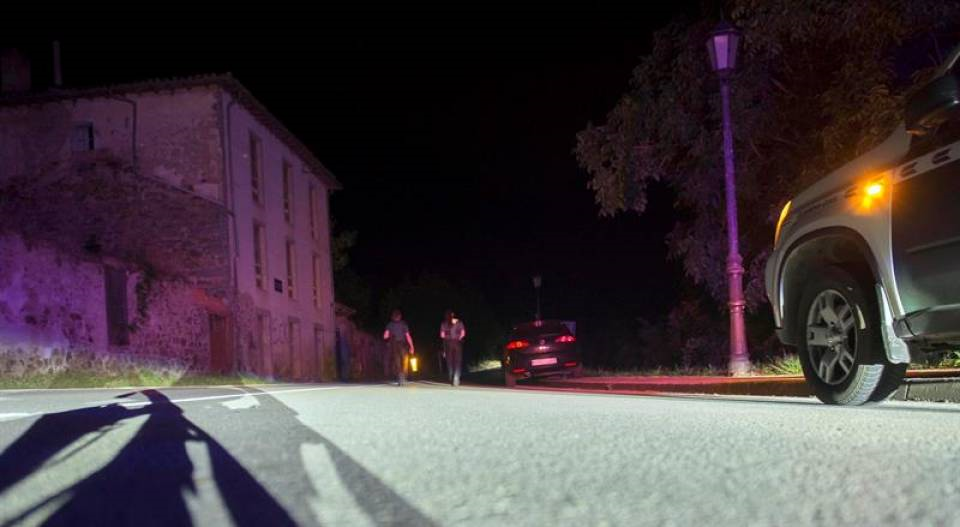 CAMALEÑO (CANTABRIA) ESPAÑA), 18.07.2018. Dos agentes de la Guardia Civil cortan la carretera que da acceso al lugar en el que un hombre lleva atrincherado desde las 21.00 hora. Efe