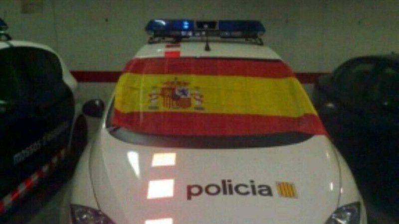 CATALUÑA (ESPAÑA), Vista de un coche patrulla de los Mozos de Escuadra en una comisaría de los Mozos de escuadra con una bandera de España. Lasvocesdelpueblo