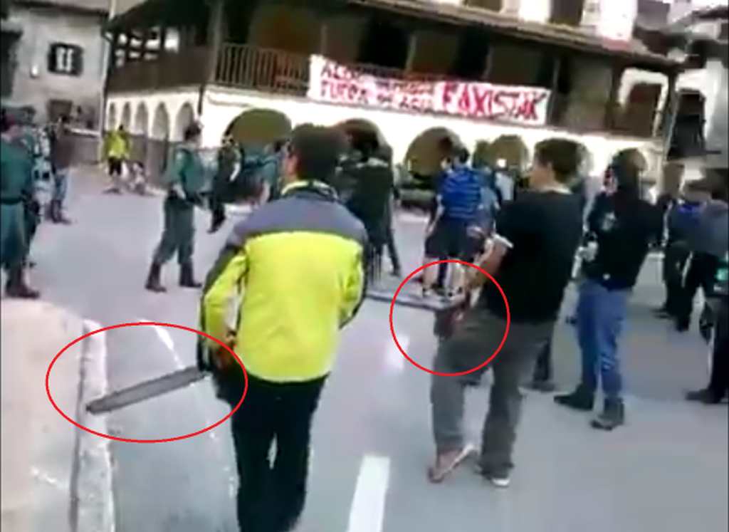 NAVARRA (ESPAÑA), AÑO 2018. Vista de dos ultra fascistas independentistas con dos motosierras, entre otros neonazis encapuchados armados de palos.. Ñ Pueblo