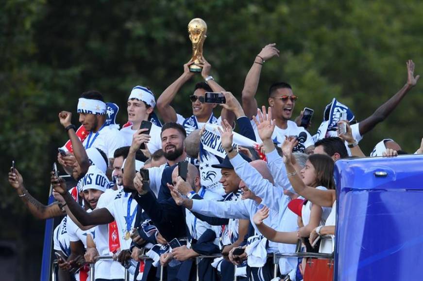 PARÍS (FRANCIA) , 16.07.2918. El defensa francés Raphael Varane (c) sostiene el trofeo junto a sus compañero durante la celebración en París de ser campeones del Mundial 2018. Efe.