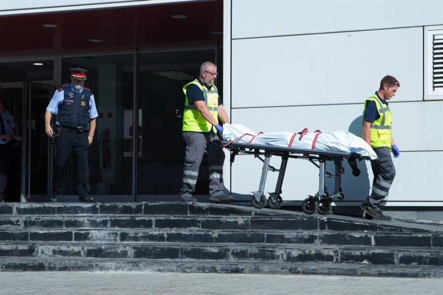 CORNELLÁ DE LLOBREGAT (BARCELONA), 20.08.2018. Miembros del servicio judicial retiran el cadáver del terrorista que ha sido abatido al intentar acceder a la comisaría de Mozos. Efe